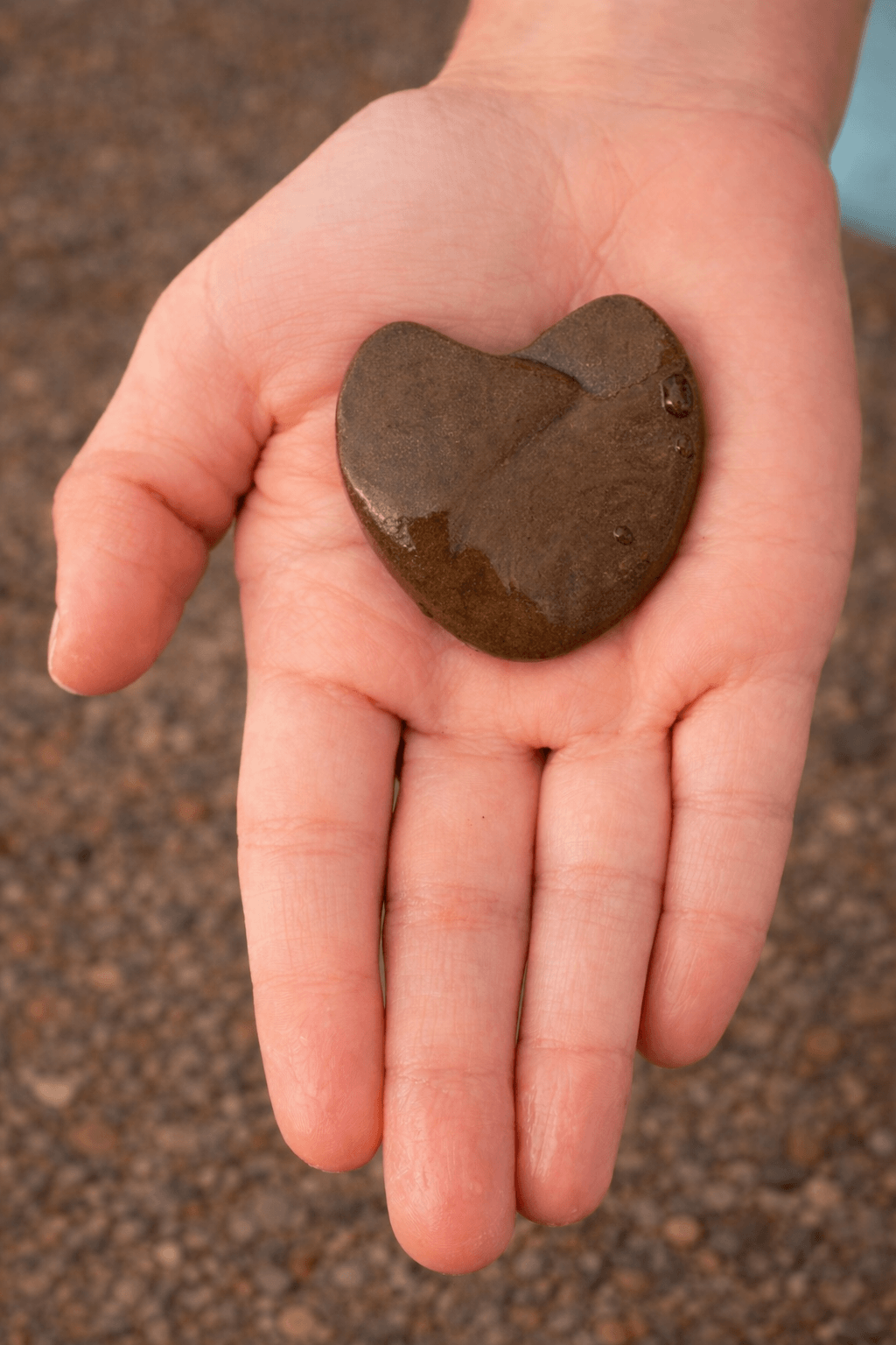 hand holding a heart shaped rock
